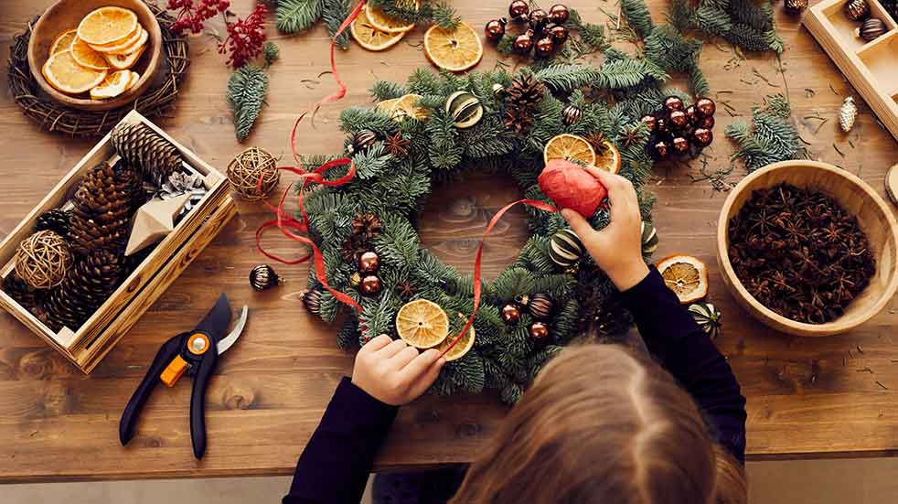 Bring the outside in girl making Christmas wreath